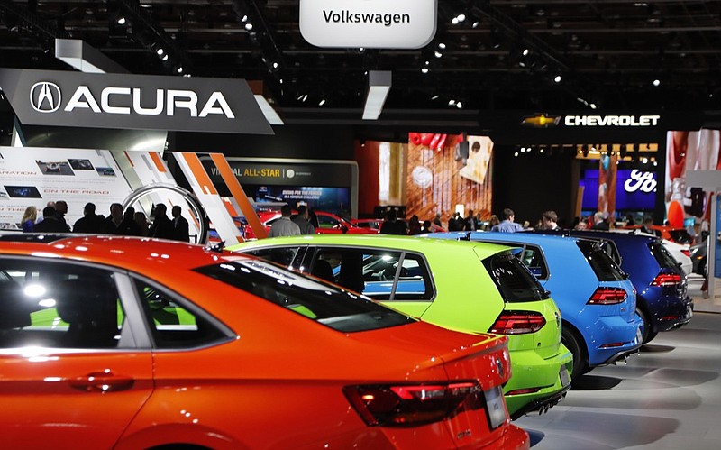 FILE - In a Jan. 15, 2019 file photo, signage for automakers Volkswagen, Acura, Chevrolet and Ford, at the North American International Auto Show in Detroit. The North American International Auto Show said that it will cancel its Detroit show because of the coronavirus pandemic and the center where it is held will likely be repurposed into a hospital. The Detroit Auto Show, as it is more commonly known, is one of the largest auto shows in North America. It was scheduled to be held in June.(AP Photo/Carlos Osorio, File)