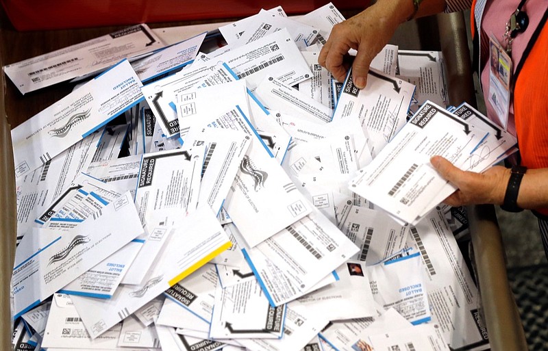 FILE - In this May 17, 2016, file photo, ballots are prepared for counting at Multnomah County election headquarters in Portland, Ore. The coronavirus has knocked presidential primaries back several weeks as officials worry about voters crowding into polling places. If the disease remains a hazard in November, Democrats say there's only one solution to preserve the November election, national voting by mail. (AP Photo/Don Ryan, File)