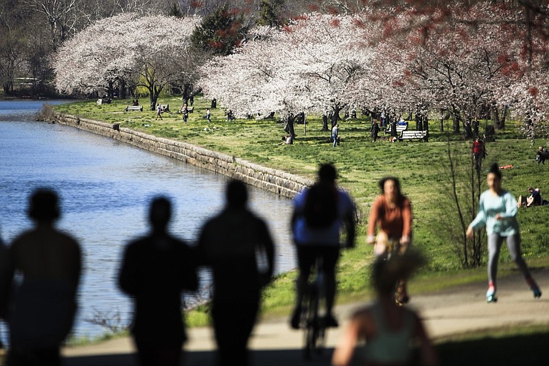 FILE - In this March 26, 2020, file photo, people exercise on the trail along Kelly Drive in Philadelphia. For millions of seasonal allergy sufferers, the annual onset of watery eyes and scratchy throats is bumping up against the global spread of a new virus that produces its own constellation of respiratory symptoms. That's causing angst for people who suffer from hay fever and are now asking themselves whether their symptoms are related to their allergies or the new coronavirus. (AP Photo/Matt Rourke, File)