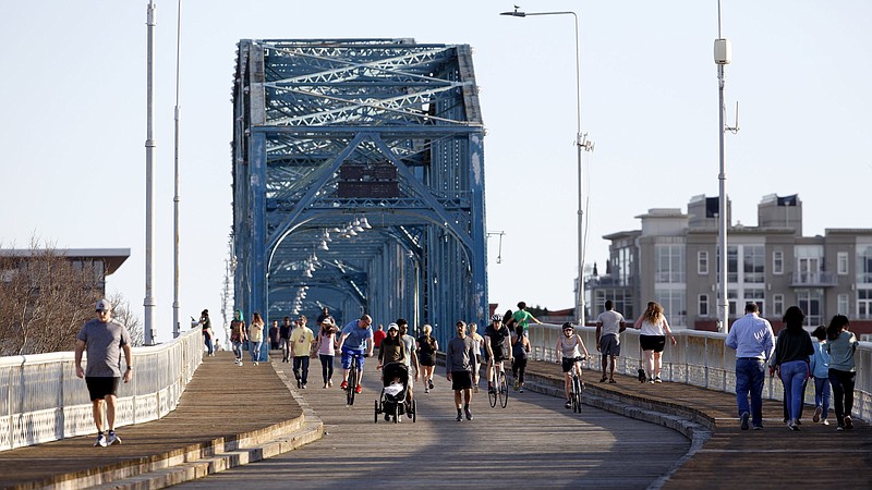 Staff photo by C.B. Schmelter / People cross the Walnut Street Bridge on Thursday, March 26, 2020 in Chattanooga, Tenn. Despite recommendations from the Centers for Disease Control and Prevention to practice social distancing, which they define as "remaining out of congregate settings, avoiding mass gatherings, and maintaining distance (approximately 6 feet or 2 meters) from others when possible," people still enjoyed the Walnut Street Bridge.
