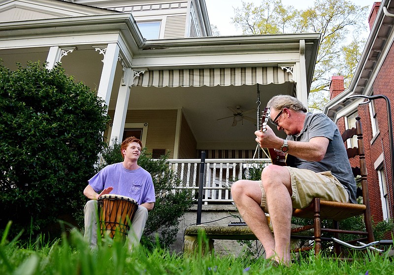 Staff Photo by Robin Rudd / Ned O'Neil plays the bongos while his father, Steve, plays the guitar. Residents of Chattanooga's Fort Wood Historic District took to their porches and yards Friday to share their talents and ward off the tension of the Coronavirus pandemic.