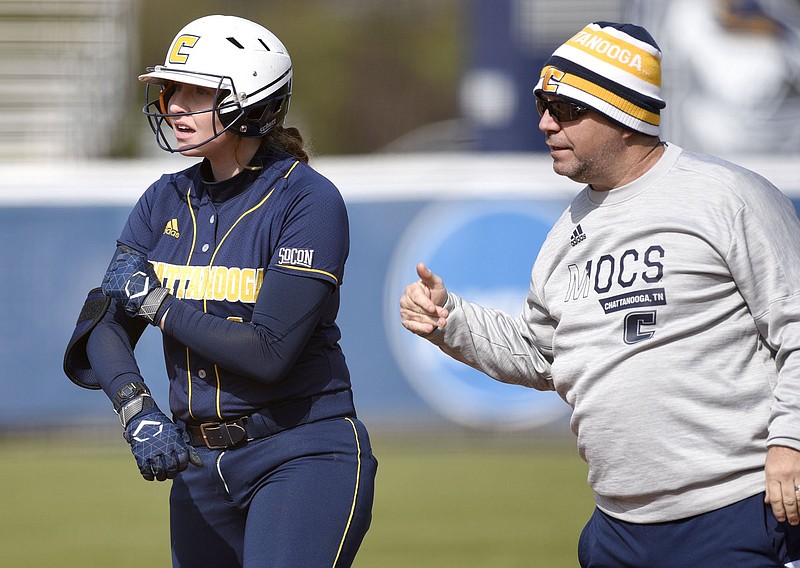 Staff photo by Robin Rudd / Scottie Kilgore, associate head coach for the UTC softball team, confers with Aly Walker at first base during the Mocs' season opener against Austin Peay on Feb. 9 at Frost Stadium. Walker is one of seven seniors on this year's team, which had its season cut short by the COVID-19 pandemic. The NCAA has ruled that all Division I spring sports athletes have been granted an extra year of eligibility.