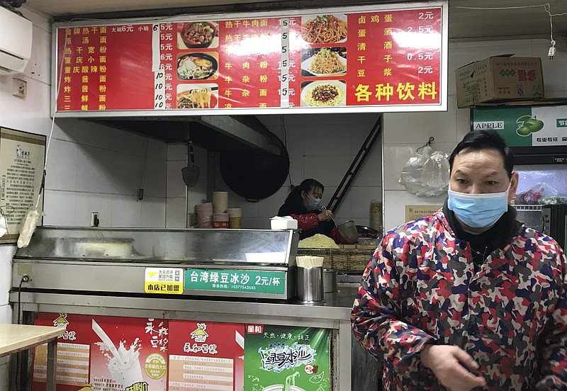 Owners of a store selling a local favorite "reganmian," or hot dry noodles, prepare takeaway orders in Wuhan in central China's Hubei province, on Tuesday.