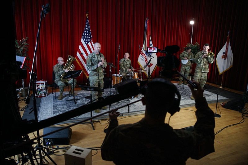 U.S. Army Field Band members from left, Chief Warrant Officer 2 Kevin Pick, on the tuba, Master Sgt. Bradford Danho, on the clarinet, Staff Sgt. Andrew Emerich, on the drums, Sgt. 1st Class Jonathan Epley, on the banjo and Staff Sgt. Kyle Johnson, on the trombone, are spaced to allow for social distancing as they play during the rehearsal of their daily "We Stand Ready" virtual concert series at Fort George G. Meade in Fort Meade, Md., Wednesday, March 25, 2020. The Army Field Band's mission is to bring the military's story to the American people. And they're not letting the coronavirus get in the way. (AP Photo/Carolyn Kaster)


