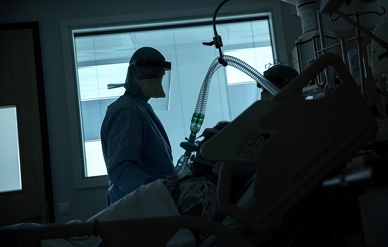 A health worker in the intensive care ward observes a COVID-19 patient at a hospital in Belgium on Friday.