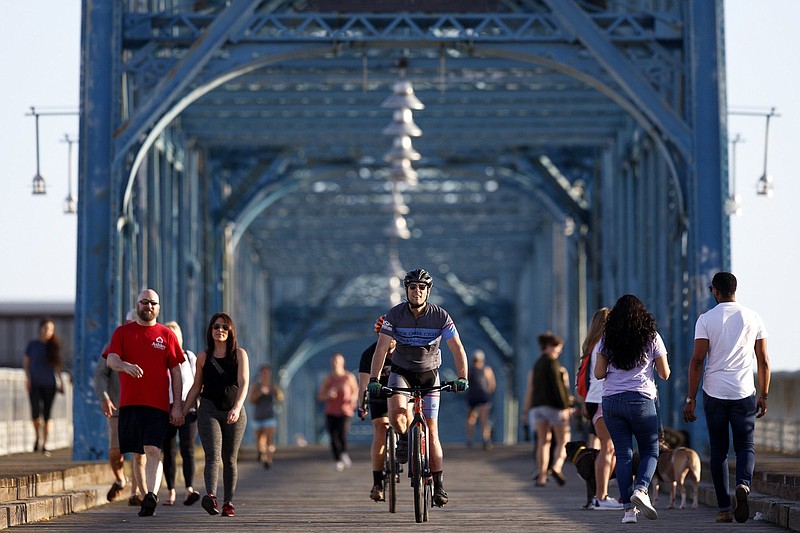 Staff photo by C.B. Schmelter / People cross the Walnut Street Bridge on Thursday, March 26, 2020 in Chattanooga, Tenn. Despite recommendations from the Centers for Disease Control and Prevention to practice social distancing, which they define as "remaining out of congregate settings, avoiding mass gatherings, and maintaining distance (approximately 6 feet or 2 meters) from others when possible," people still enjoyed the Walnut Street Bridge.