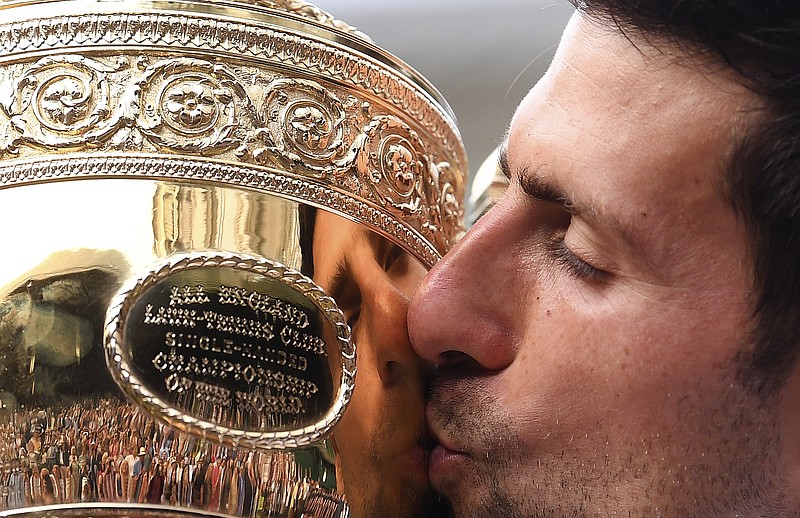 AP photo by Laurence Griffiths / Novak Djokovic kisses the trophy after beating Roger Federer in the Wimbledon men's singles final on July 14, 2019.