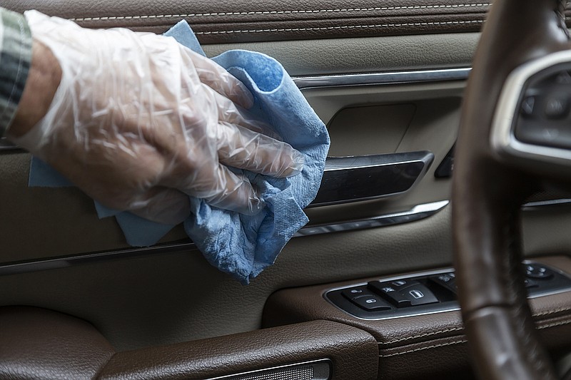 In this undated photo from Edmunds, common touch points are wiped down in the interior of a vehicle, which is one way to reduce the risk of spreading the coronavirus inside the cabin. Apply disinfectant using wipes or spray disinfectant onto a soft cloth, and use disposable gloves to protect your hands. (Scott Jacobs/Edmunds via AP)


