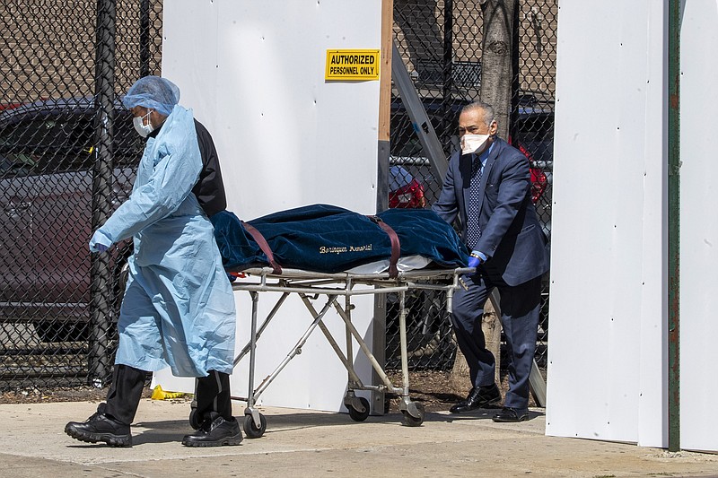 A funeral director and a Wycoff Heights Medical Center, employee transport a body, Wednesday, April 1, 2020, in New York. The new coronavirus causes mild or moderate symptoms for most people, but for some, especially older adults and people with existing health problems, it can cause more severe illness or death. (AP Photo/Mary Altaffer)


