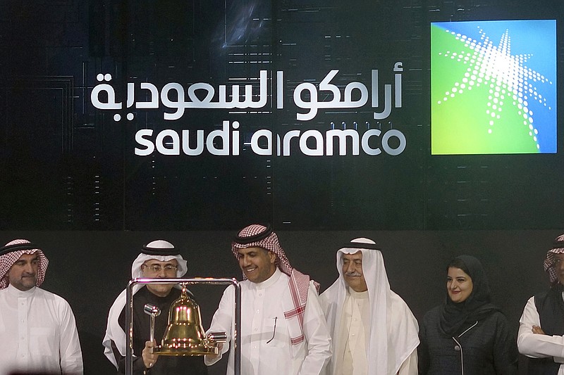 FILE - In this Dec. 11, 2019, file photo, Saudi Arabia's state-owned oil company Armco and stock market officials celebrate during the official ceremony marking the debut of Aramco's initial public offering (IPO) on the Riyadh's stock market, in Riyadh, Saudi Arabia. Saudi Arabia's oil company Aramco said Wednesday, march 11, 2020, it will increase production capacity to 13 million barrels per day, up from 12 million per day, part of a strategy to dominate market share amid a slowdown in demand due to the outbreak of a new virus. (AP Photo/Amr Nabil, File)
