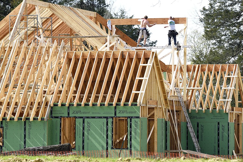 Staff Photo by Robin Rudd / Carpenters work on the roof of a house being build on Julian Road, at the former site of the Joe Engel Farm, on March 27, 2020.
