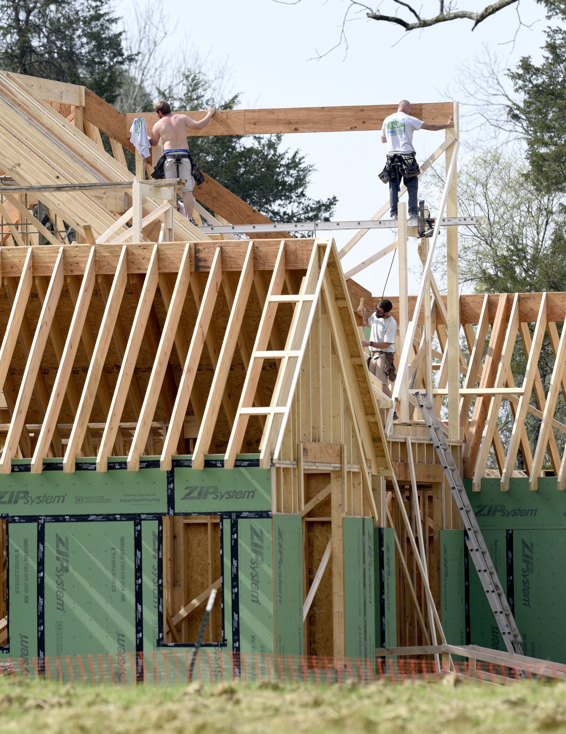 Staff Photo by Robin Rudd / Carpenters work on the roof of a house being build on Julian Road, at the former site of the Joe Engel Farm, on March 27, 2020.