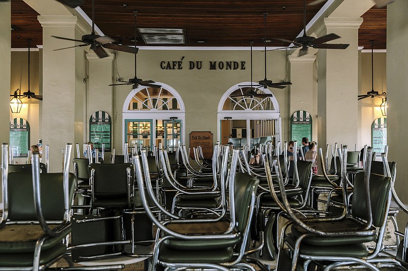 File photo by William Widmer of The New York Times / The iconic Cafe Du Monde in New Orleans, famously popular with tourists, is open only for take out service on March 17, 2020, as a result of the coronavirus pandemic. Millions are losing their jobs and economies are suffering as once-bustling tourist sites give way to eerie emptiness.