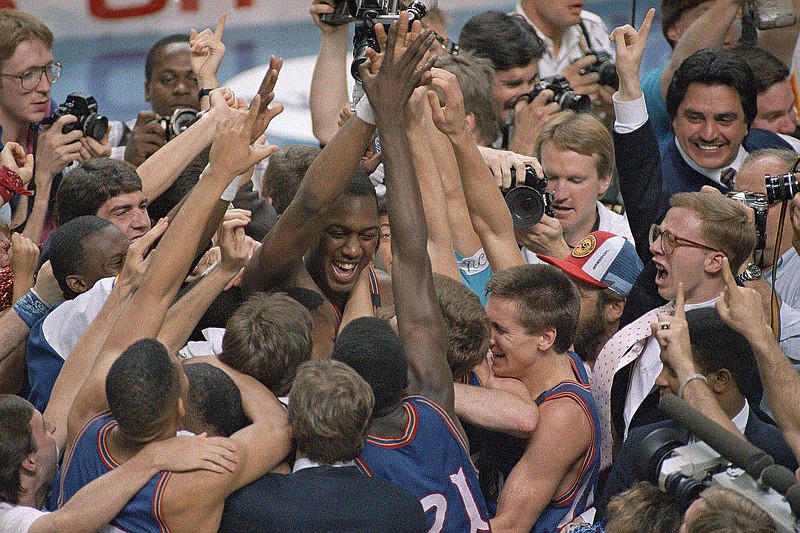 AP photo by Susan Ragan / Danny Manning, facing camera at center left, is mobbed by his Kansas basketball teammates and fans after he led the Jayhawks to an 83-79 victory over Oklahoma in the NCAA tournament final on April 4, 1988, in Kansas City, Mo. Manning orchestrated one of the biggest upsets in the history of the championship game with his 31 points, 18 rebounds and five steals.