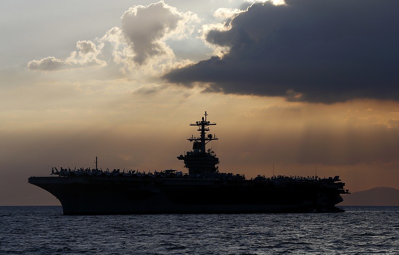 FILE - In this April 13, 2018, file photo the USS Theodore Roosevelt aircraft carrier is anchored off Manila Bay west of Manila, Philippines. The captain of the U.S. Navy aircraft carrier facing a growing outbreak of the coronavirus is asking for permission to isolate the bulk of his roughly 5,000 crew members on shore, which would take the warship out of duty in an effort to save lives. The ship is docked in Guam (AP Photo/Bullit Marquez, File)


