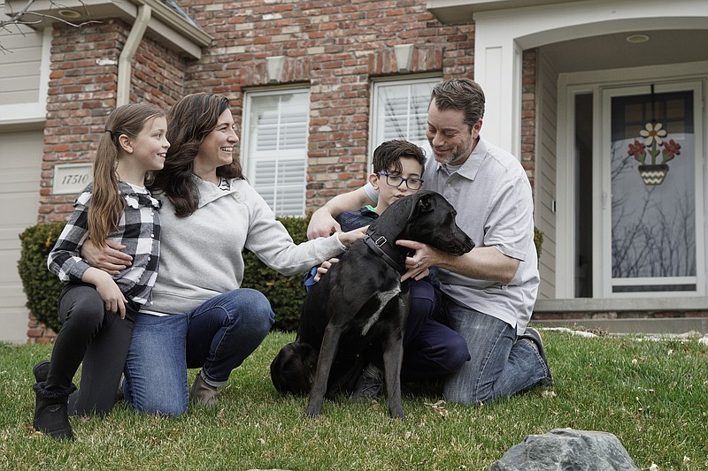 In this March 27, 2020, photo, Kim Simeon; her husband, Adam; and children, Annabel, 9, and Brennan, 11, pose for a photo with Nala, a dog they are fostering, in Omaha, Neb. The Simeon family was headed home to Omaha from a much-needed Smoky Mountains vacation when Kim Simeon spotted a social media post from the Nebraska Humane Society, pleading with people to consider fostering a pet. (AP Photo/Nati Harnik)


