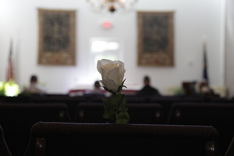 In this Friday, April 3, 2020, photo, a white rose is pinned to an empty chair during J. Robert Coleman's funeral in Lexington, S.C. Thompson Funeral Homes added the flowers to represent the loved ones who couldn't attend in the midst of the coronavirus pandemic. (AP Photo/Sarah Blake Morgan)


