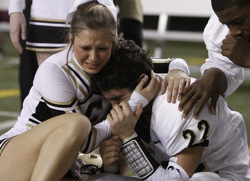 Staff photo by Dan Henry / Calhoun High School cheerleader Maci Beaver cries with her twin brother, Yellow Jackets senior safety Chance Beaver, after their team lost 31-24 in overtime to Buford in the GHSA Class AA football state championship game on Dec. 3, 2010, at the Georgia Dome in Atlanta. It was the third straight year Calhoun lost the title game to Buford.