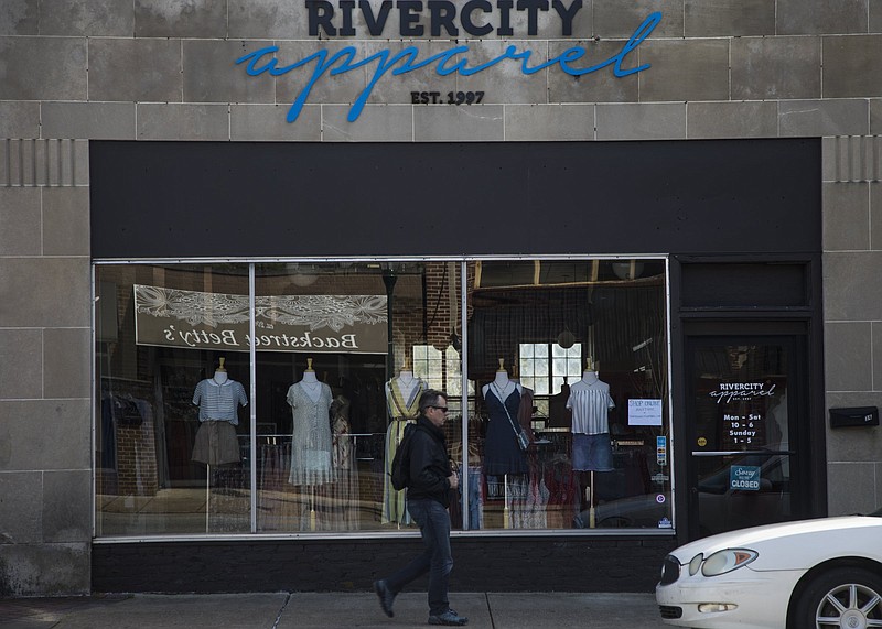 Staff photo by Troy Stolt / An unidentified person walks past Rivercity Apparel on Fraizer Ave. on Thursday, April 2, 2020 in Chattanooga, Tenn. Mayor Andy Berke announced Executive Order 2020-06 on Thursday, closing all non-essential businesses.
