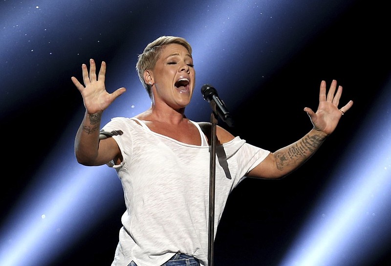 FILE - In this Jan. 28, 2018, file photo, Pink performs "Wild Hearts Can't Be Broken" at the 60th annual Grammy Awards at Madison Square Garden in New York. We are all learning a lot about each other these days and that's especially true with our celebrities. Social distancing has meant they have no army of publicists or glam squad. While many influencers and stars continue to post a flood of flattering, carefully stage-managed images, others are mirroring us — unshaven, unwashed and not ashamed. "When I drink, I get really, really brilliant ideas," the singer Pink confessed recently. "And last night, I got an idea — I can cut hair. I can totally cut hair. Why have I been paying people all this time?" She then reveals some choppy, shaved spots on her head. (Photo by Matt Sayles/Invision/AP, File)