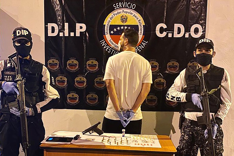 In this March 31, 2020, photo, Venezuelan police officers present a suspect arrested at a multiday party in Caracas, Venezuela, that violated Nicolas Maduro's order on large gatherings during the coronavirus pandemic. (Courtesy of Venezuelan Chief Prosecutor's Office via AP)


