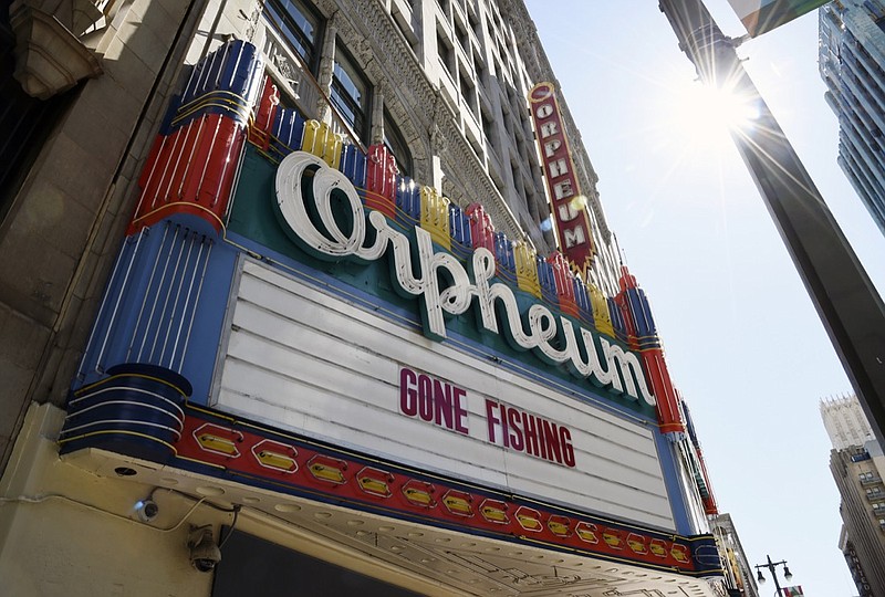 FILE - In this March 25, 2020 file photo, a "Gone Fishing" message is posted on the closed Orpheum Theatre's marquee in Los Angeles. Movie theaters may be closed, but friends are still finding ways to watch together while staying apart thanks to applications like Netflix Party. Movie studios are getting in on the action too, with "watch parties" for old favorites like "Legally Blonde" and new releases like "Emma" on Facebook and Twitter. (AP Photo/Chris Pizzello, File)