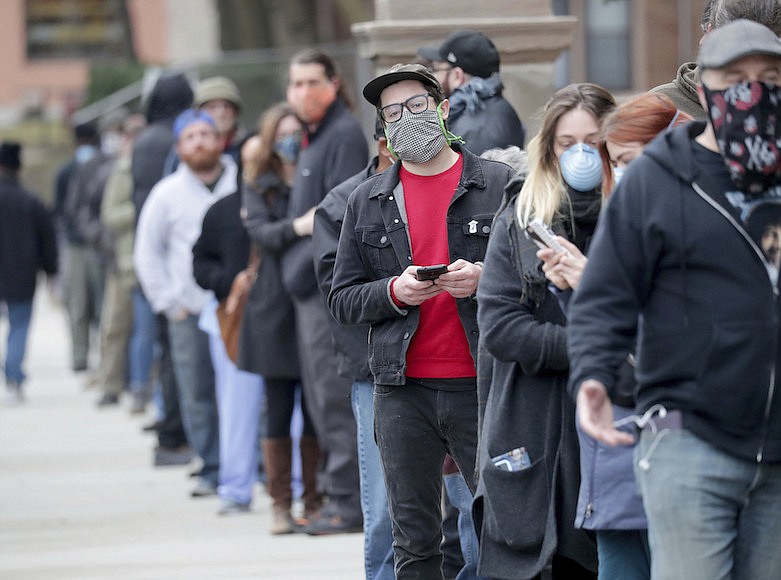 People line up to vote at Riverside High School during the primary in Milwaukee on Tuesday, April 7, 2020. Voters lined up to cast ballots across Wisconsin on Tuesday, ignoring a stay-at-home order in the midst of the coronavirus pandemic to participate in the state's presidential primary election. (Mike De Sisti/Milwaukee Journal-Sentinel via AP)