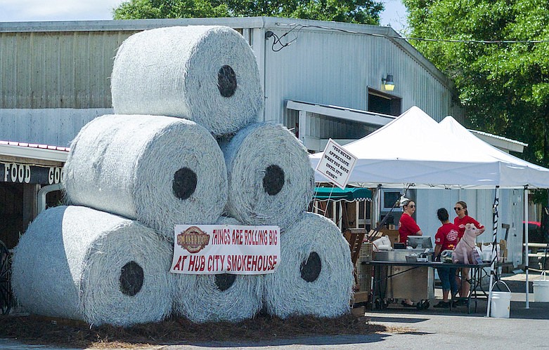 A whimsical display fashioned like giant high-demand toilet paper rolls draws attention to Hub City Smokehouse's curbside service on Main Street in historic downtown Crestview, Fla., Tuesday, April 7, 2020. (Michael Snyder/Northwest Florida Daily News via AP)