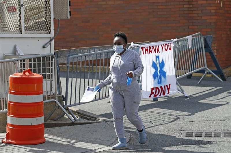 A woman leaves Elmhurst Hospital Center after being tested for COVID-19 or coronavirus during the current viral pandemic, Tuesday, April 7, 2020, in the Queens borough of New York. The new coronavirus causes mild or moderate symptoms for most people, but for some, especially older adults and people with existing health problems, it can cause more severe illness or death. (AP Photo/Kathy Willens)


