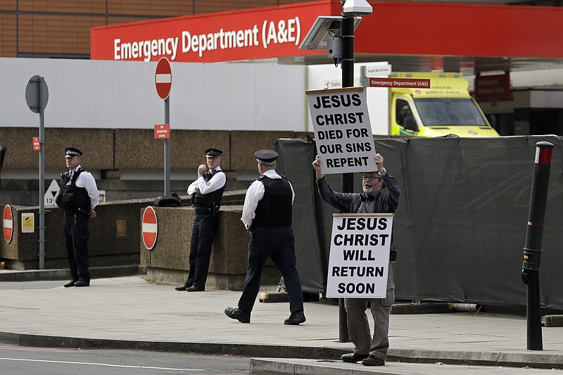 A man holds up a sign outside St Thomas' Hospital in central London, where Prime Minister Boris Johnson remains in intensive care as his coronavirus symptoms persist, Wednesday, April 8, 2020. Johnson has spent his second night in hospital intensive care. The new coronavirus causes mild or moderate symptoms for most people, but for some, especially older adults and people with existing health problems, it can cause more severe illness or death. (AP Photo/Matt Dunham)


