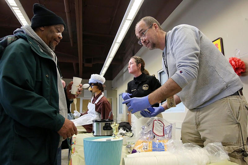 Staff photo by Erin O. Smith / Kenneth Neville lets Mike Pettross, a photo technician with the Chattanooga Police Department's crime scene investigations department, know what toppings he wants on his chili during a Battle of the Badges chili cook-off at the Chattanooga Community Kitchen Tuesday, January 29, 2019.