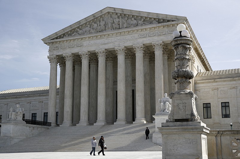 In this March 16, 2020 photo, people walk outside the Supreme Court in Washington. (AP Photo/Patrick Semansky)


