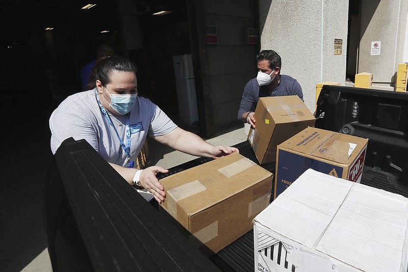Christina Caldwell, left, of Henry Ford Population Health helps unload supplies with Matt Thatcher, who donated them from the Detroit Golf Club, Wednesday, April 8, 2020, in Detroit. The hospital is also in need of gowns and other PPE items and hopes more donations will be coming in from others to help during the coronavirus pandemic. (AP Photo/Carlos Osorio)



