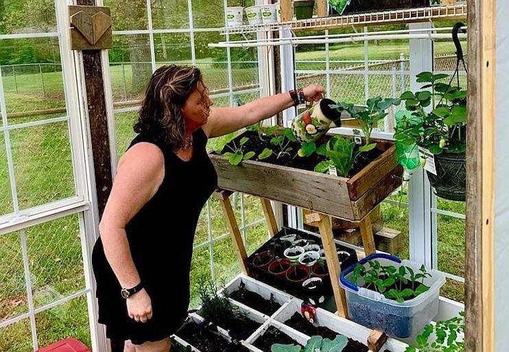 Dana Malone waters plants in the greenhouse she and husband Shawn built on their Hixson property. / Contributed photo by Dana and Shawn Malone
