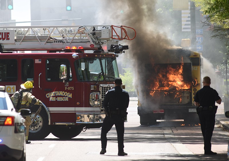 Staff photo by Tim Barber/ Chattanooga police are first on the scene of a CARTA bus that caught fire in the 800 block of Market Street shortly after 1:30 p.m. Friday, Apr. 10, 2020.
