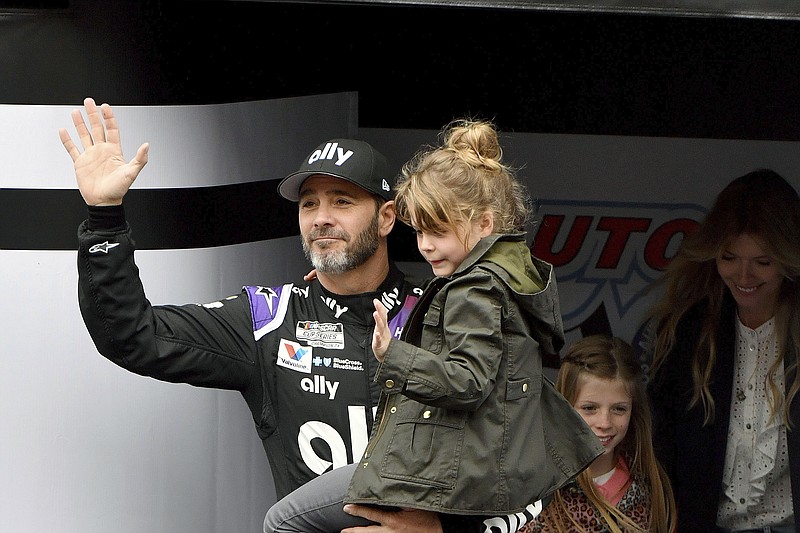 AP photo by Will Lester / NASCAR driver Jimmie Johnson, a seven-time Cup Series season champion, is introduced to the crowd at Auto Club Speedway on March 1 in Fontana, Calif., as he carries his youngest daughter Lydia and his oldest daughter Genevieve and wife Chandra follow them.