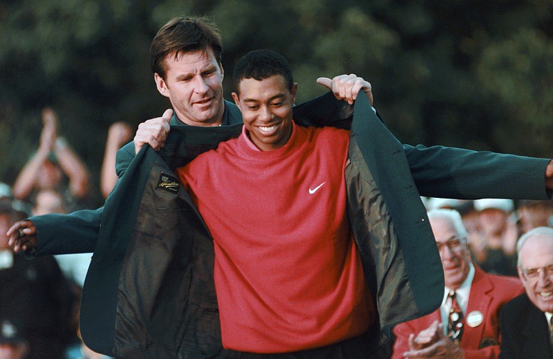 AP photo by Dave Martin / Masters champion Tiger Woods receives his green jacket from Nick Faldo, the previous year's champion, after winning the 1997 tournament at Augusta National Golf Club for his first of what is now five Masters titles and 15 major championships.