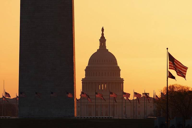 FILE - In this March 18, 2020, file photo, the Washington Monument and the U.S. Capitol are seen in Washington, at sunrise. Congress is considering ways to govern from afar during the coronavirus pandemic. Lawmakers are talking this week about whether it's possible to conduct virtual committee meetings, particularly to oversee how the $2.2 trillion stimulus money is being spent. And they're considering ways to pass virus-related legislation without requiring every lawmaker to be present. (AP Photo/Carolyn Kaster, File)


