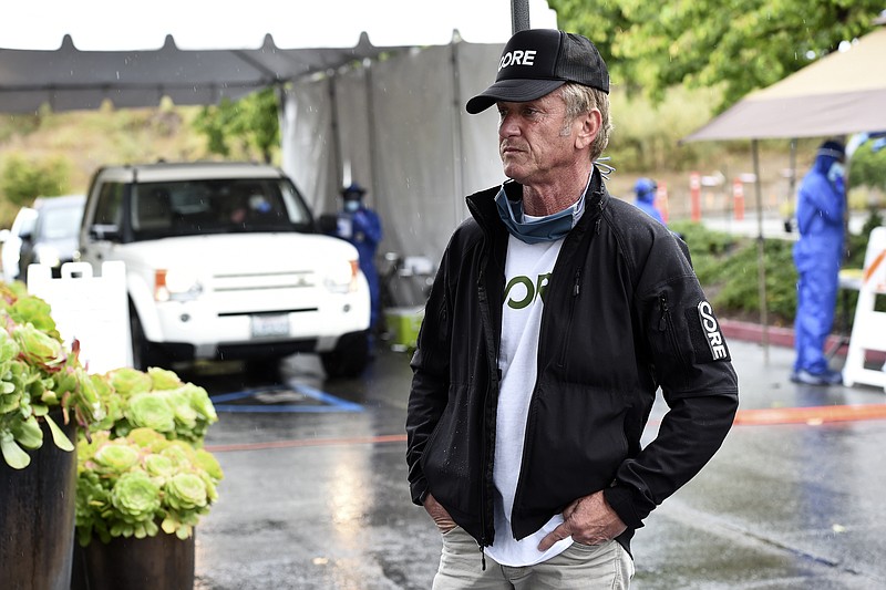 In this April 9, 2020 photo, actor and activist Sean Penn, founder of the nonprofit organization Community Organized Relief Effort (CORE), stands outside a CORE coronavirus testing site at Malibu City Hall in Malibu, Calif. The Oscar winner's disaster relief organization has teamed up with Los Angeles Mayor Eric Garcetti's office and the city's fire department to safely distribute free drive-through COVID-19 test sites for those with qualifying symptoms. (AP Photo/Chris Pizzello)