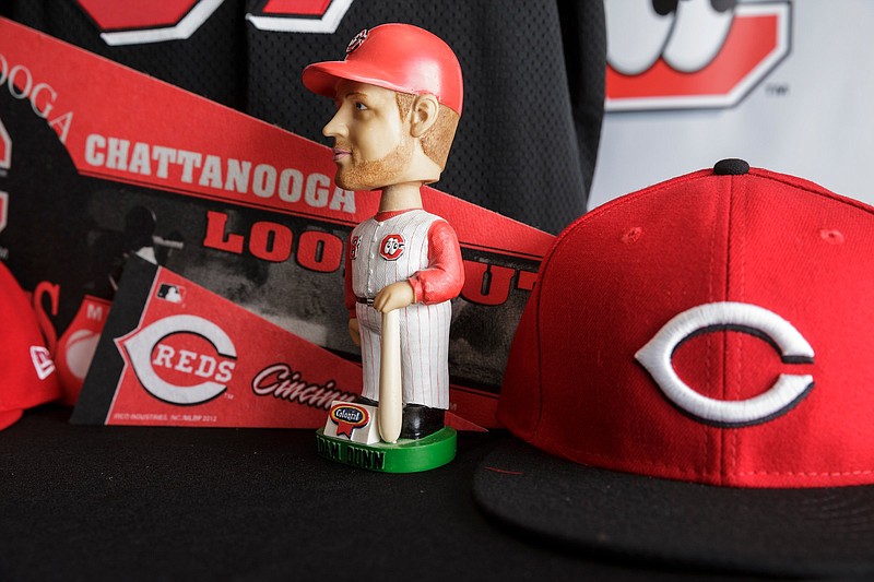 Staff file photo / A bobblehead figure of former Chattanooga Lookouts player Adam Dunn is displayed with Cincinnati Reds merchandise during a September 2018 news conference announcing a two-season partnership between the teams. The Lookout were also affiliated with the Reds from 1988 to 2008 before having player development contracts with the Los Angeles Dodgers (2009-14) and then the Minnesota Twins (2015-18).