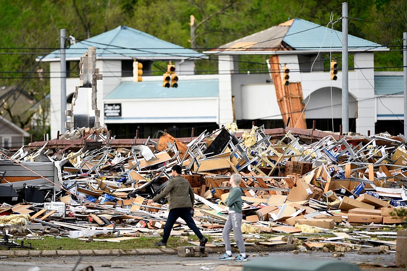 Staff Photo by Robin Rudd / People walk past the rubble of the Advanced Auto Parts Store in the 7600 block of East Brainerd Road on April 13, 2020.  The Chattanooga area was hit by severe storms on at the night of April 12, 2020. 
