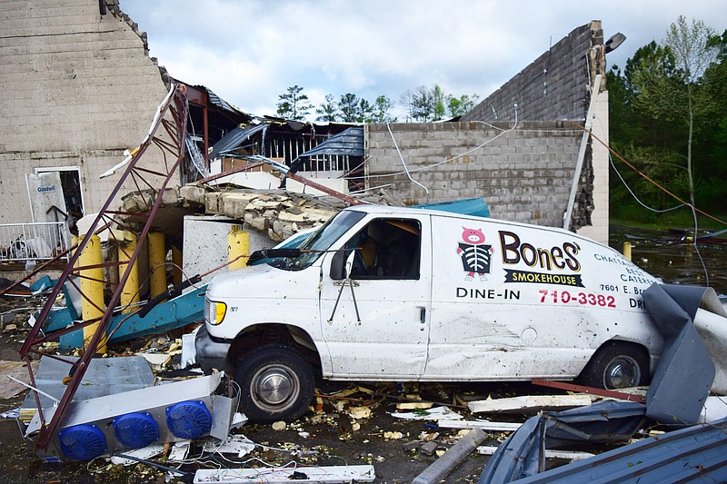 Staff Photo by Robin Rudd / A Bones Smokehouse delivery van was crushed by a fallen wall from the GoodWill Store on East Brainerd and restaurant was also severely damaged in severe storms that hit the Chattanooga area on the night of April 12, 2020. 
