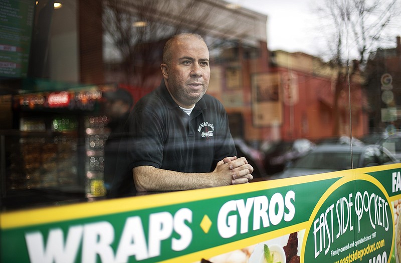 Photo by David Goldman of The Associated Press / Paul Boutros, owner of East Side Pockets, a small restaurant near Brown University, looks out onto an empty street since students were sent home on Wednesday, March 25, 2020, in Providence, Rhode Island.