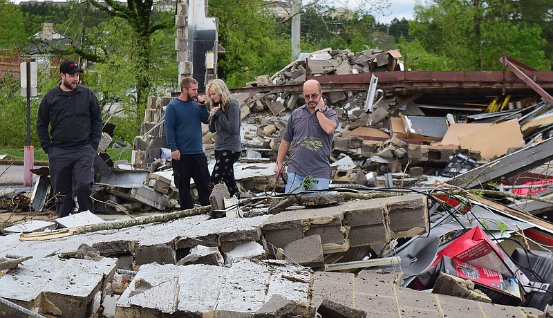 Staff Photo by Robin Rudd / Employees of Advanced Auto, who preferred not to be identified, walk through the rubble of their store in the 7600 block of East Brainerd Road. The South — and the Chattanooga area — were hit by severe storms and tornadoes on Easter night.