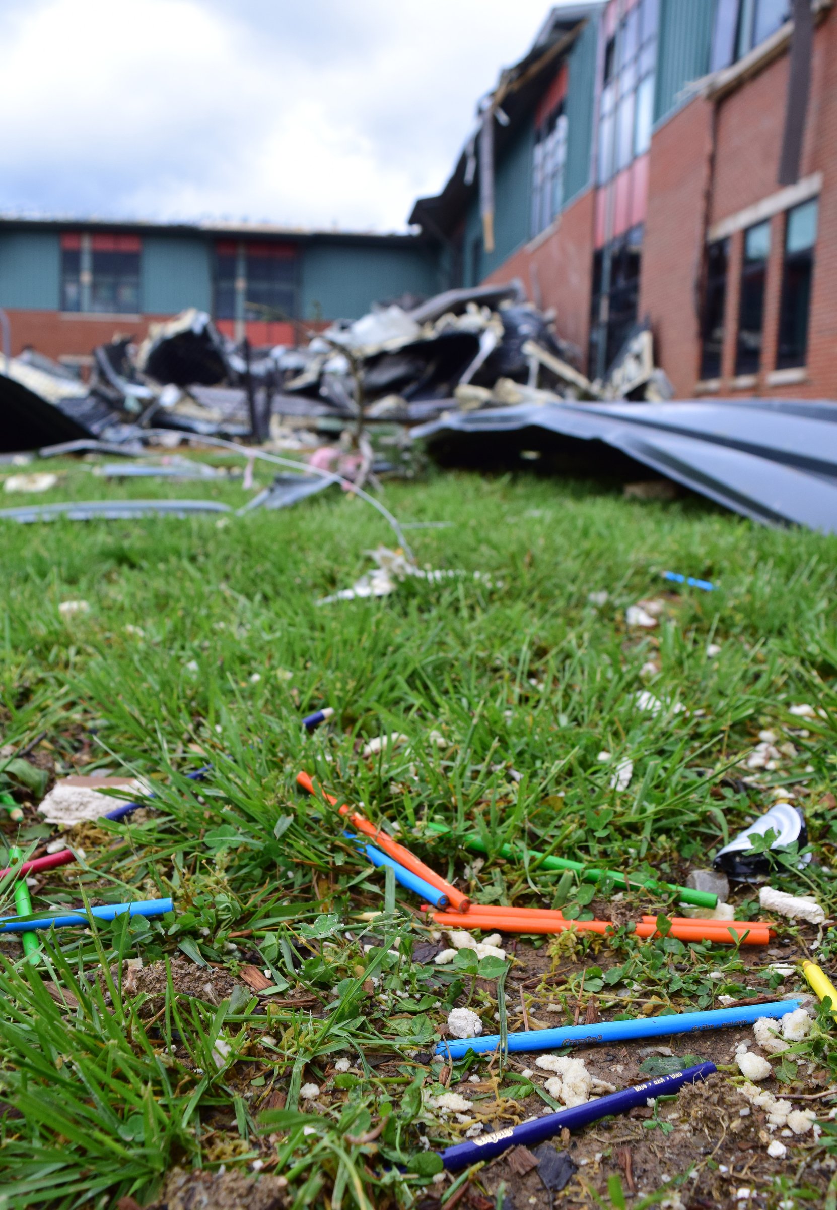 Staff Photo by Robin Rudd / Colored-pencils are seen scattered on the grass outside the heavily damaged East Brainerd Elementary School. The Chattanooga Area was hit by severe storms on the night of April 12, 2020.