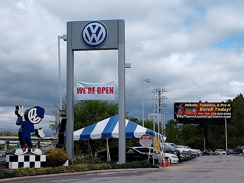 Staff photo by Mike Pare / A sign at Village Volkswagen of Chattanooga tells people the auto dealership remains open during the coronavirus pandemic.