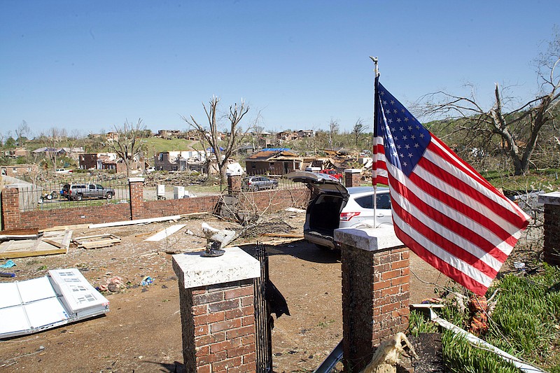 Staff photo by Wyatt Massey /An American flag waves outside Heather Nelson's home in the Holly Hills subdivision of Chattanooga on April 14. A tornado destroyed homes in the area early on April 13. Nelson found the flag under the debris near her house and put it up.