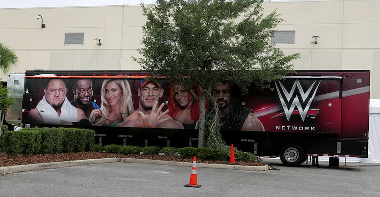 A trailer set up near a satellite truck to transmit wrestling broadcasts is parked outside the WWE Performance Center Tuesday, April 14, 2020, in Orlando, Fla. Florida's top emergency official last week amended Gov. Ron DeSantis' stay-at-home order to include employees at the professional sports and media production with a national audience, if the location is closed to the public. (AP Photo/John Raoux)