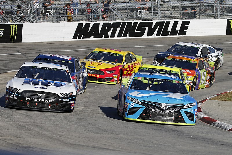 AP photo by Steve Helber / Martin Truex Jr., right, and Clint Bowyer lead the field through turn four at Virginia's Martinsville Speedway during a NASCAR Cup Series race on Oct. 27, 2019.