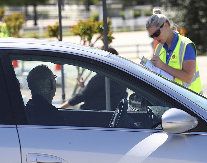 A health care worker checks in an elderly man with an appointment at a pilot large scale drive-through COVID-19 testing site at the Georgia International Horse Park on Thursday, April 16, 2020, in Conyers, Ga. Testing is by appointment only and open to anyone in the general public who believes they are ill with COVID-19. According to Chad Wasdin, communications director for the Gwinnett Rockdale Newton Health Departments, due to increased testing capacity 400 appointments are scheduled for anyone who thinks they may be ill with the virus. While the Health Department requires a scheduled appointment to test individuals, referral from a doctor is not necessary. There is no charge for the testing, and those tested do not need to provide health insurance information. "We look forward to piloting this large-scale test site," said Dr. Audrey Arona, district health director and CEO of Gwinnett, Newton and Rockdale County Health Departments. "This is a fantastic collaboration between Rockdale and Newton county governments, their EMAs, and the Health Department. Testing will provide individuals in the community an opportunity to learn if their illness is consistent with the COVID-19 virus, and it will help us improve our plans for providing large-scale testing. (Curtis Compton/Atlanta Journal-Constitution via AP)


